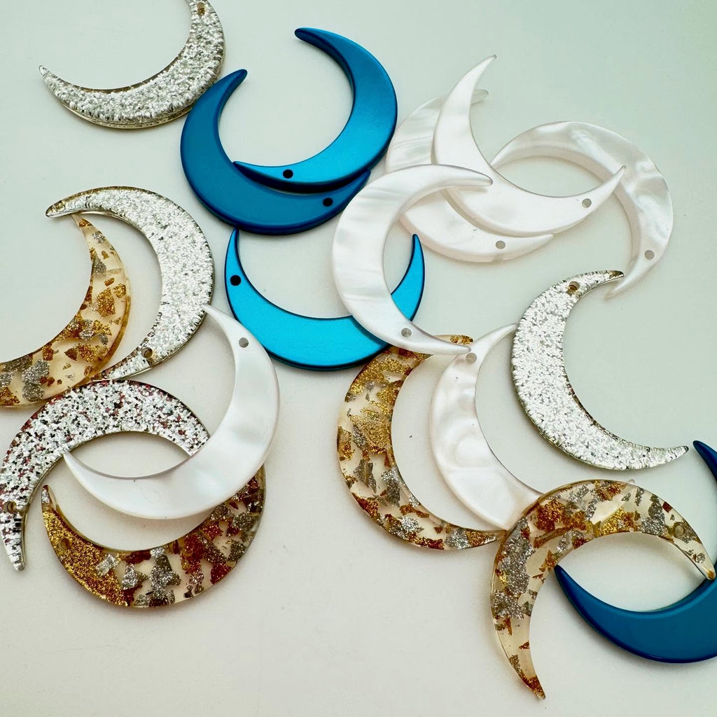 Decorative moon-shaped items in various colors on a light background