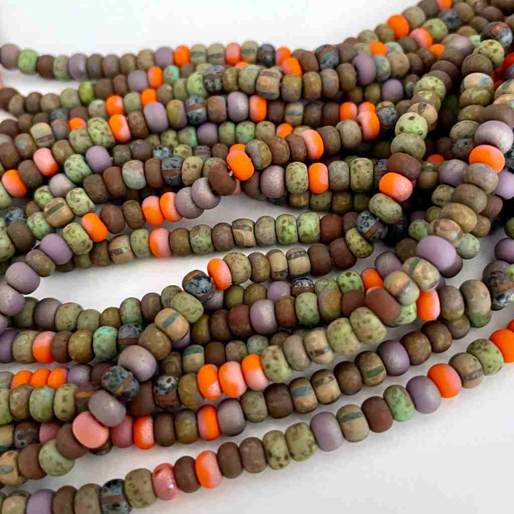 earthy colored strands of seed beads with a matte finish with a pop of orange