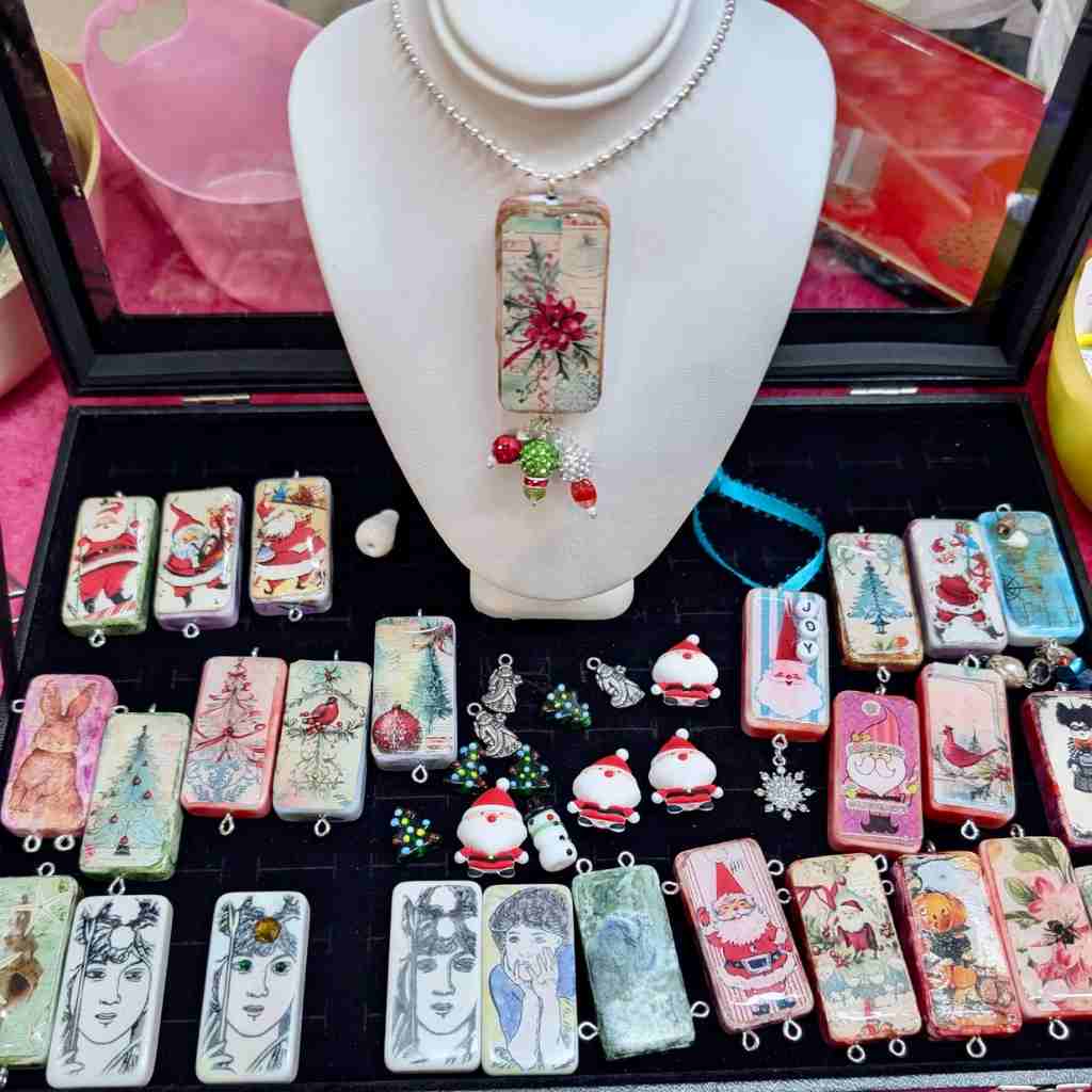 Collection of decorative Domino pendants and jewelry on a display stand.