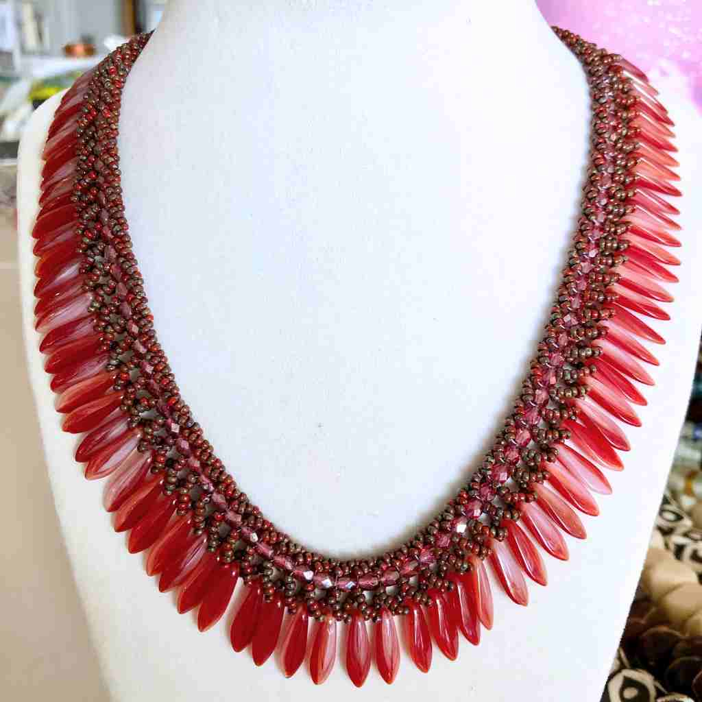 Bi-color burgundy cream dagger beads in a collar style beaded necklace