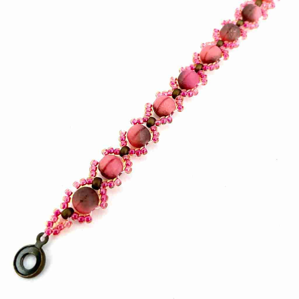 coral colored bracelet with seed bead x shape and round beads