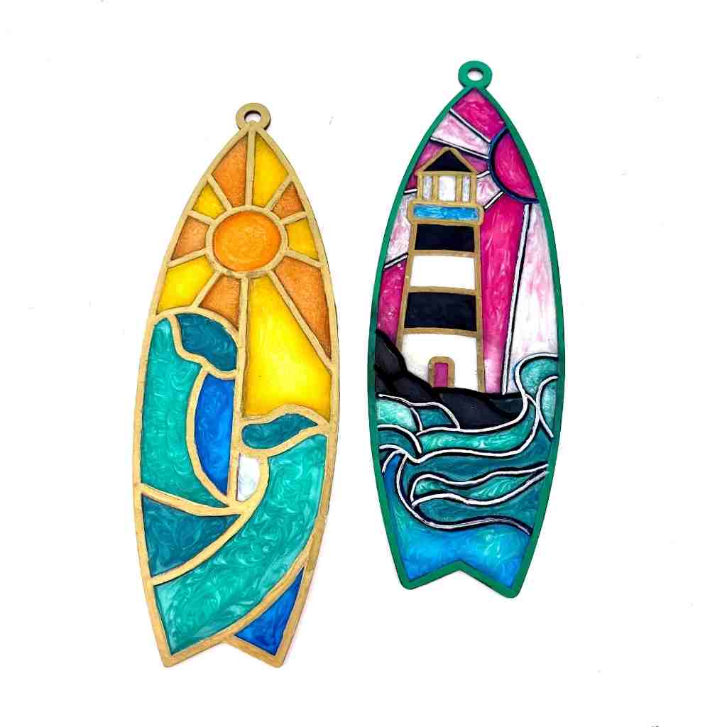 Two colorful resin suncatchers with a sun and lighthouse design on a white background.