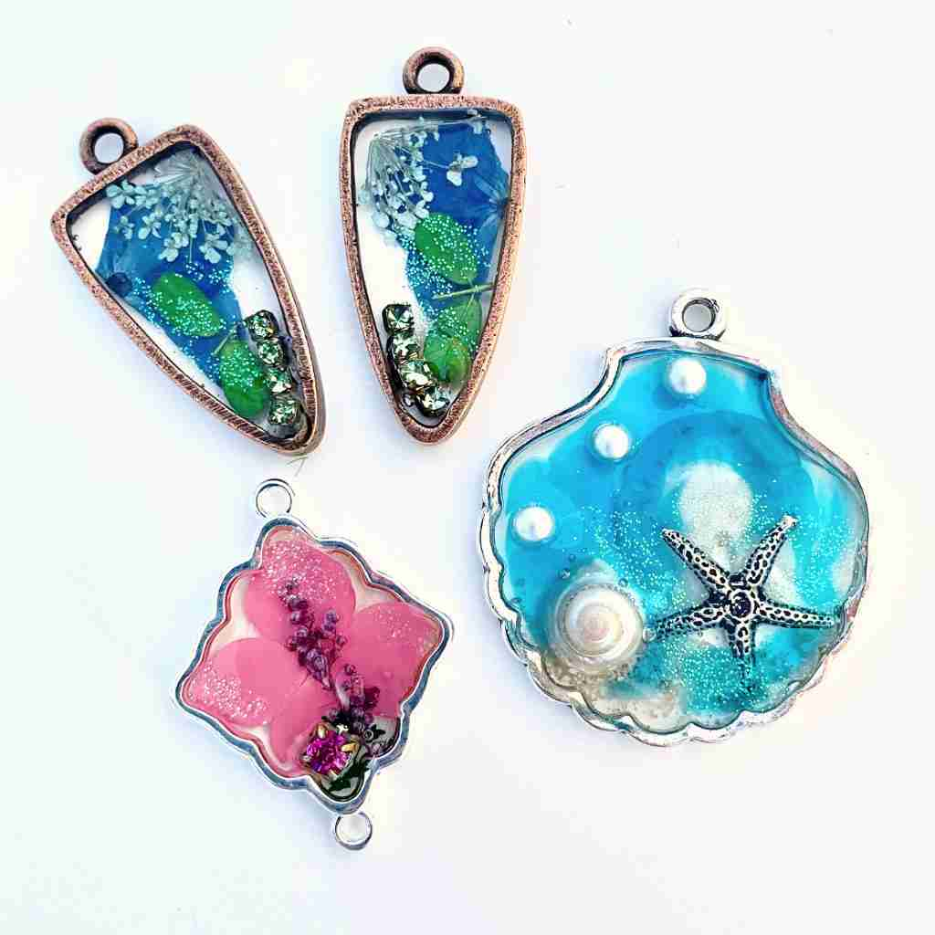 Seashell shaped bezel filled with beach themed resin, others filled with dried flowers