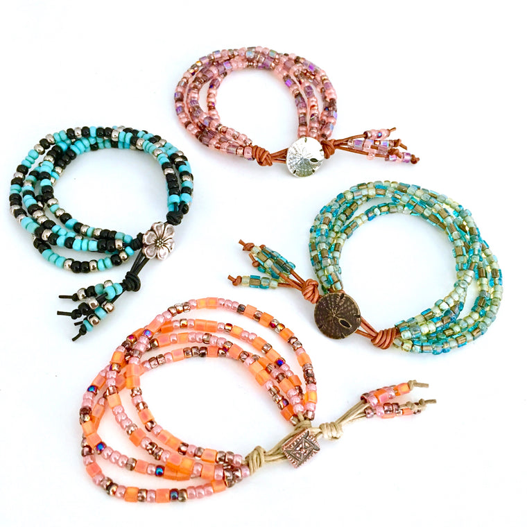 The Wildflower Bracelet Class yields these multi colored 4 strand beaded braclets on fine leather or cotton cording with a fancy metal button clasp/Island Cove Beads & Gallery
