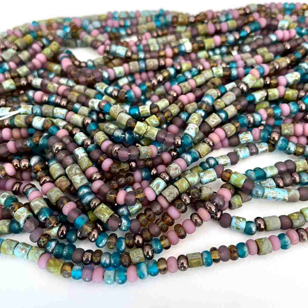 strands of seed beads interspersed with tube shaped beads in soft rose, turquoise, olives and browns