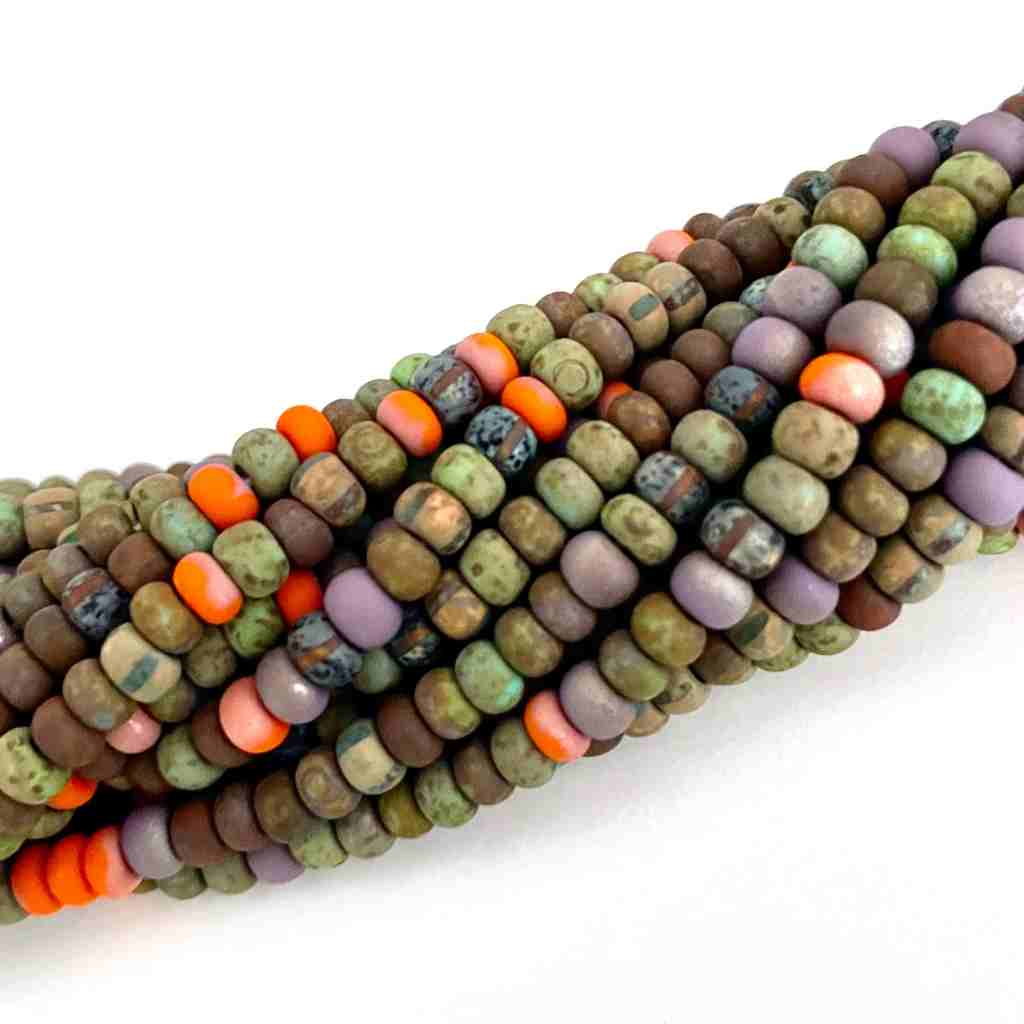 earthy seed beads with a matte finish with an occasional  orange bead twisted into a roll