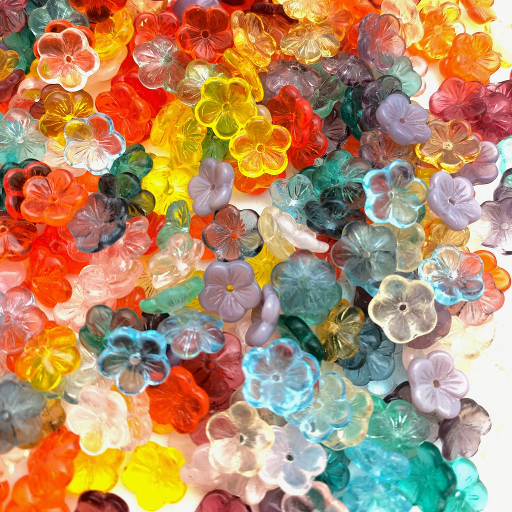 Colorful assortment of transparent flower-shaped beads on a white background