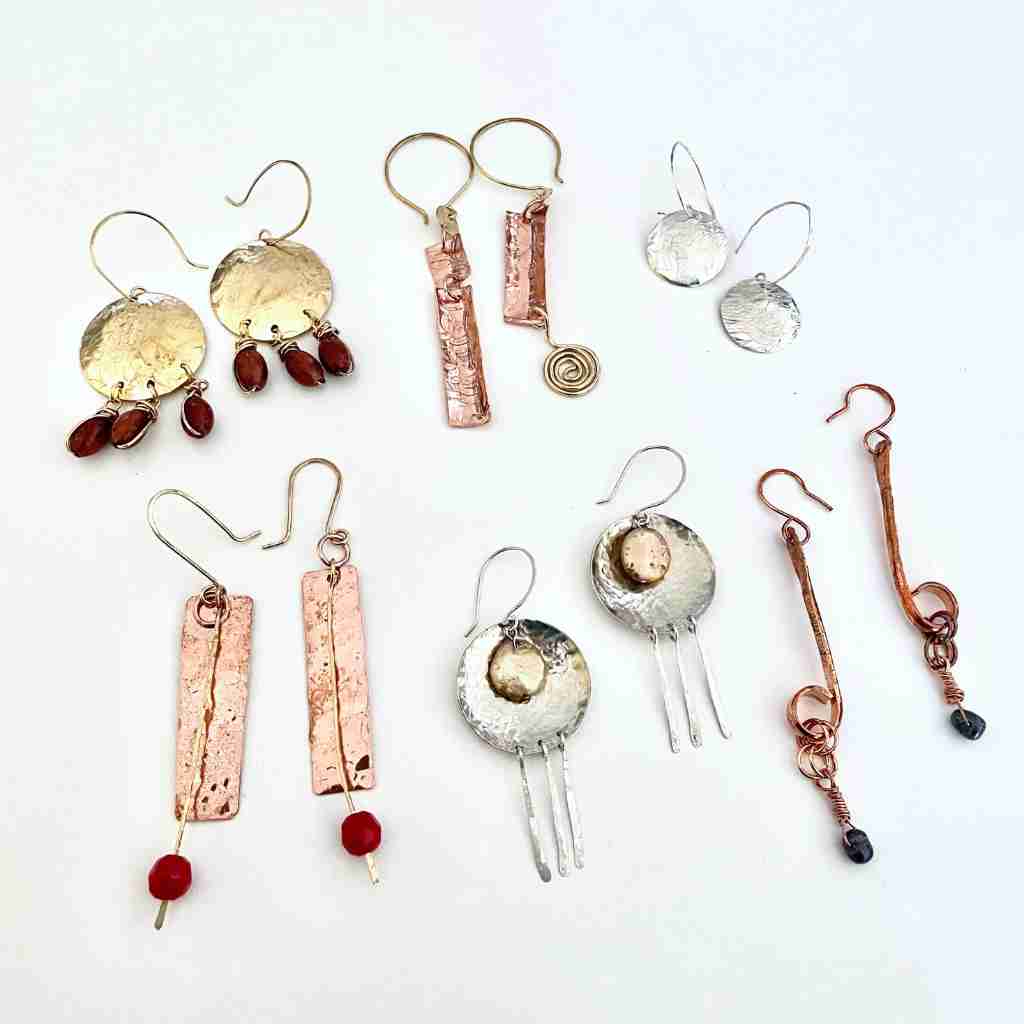 collection of hammered brass, copper and silver shaped earrings embellished with beads and dangles