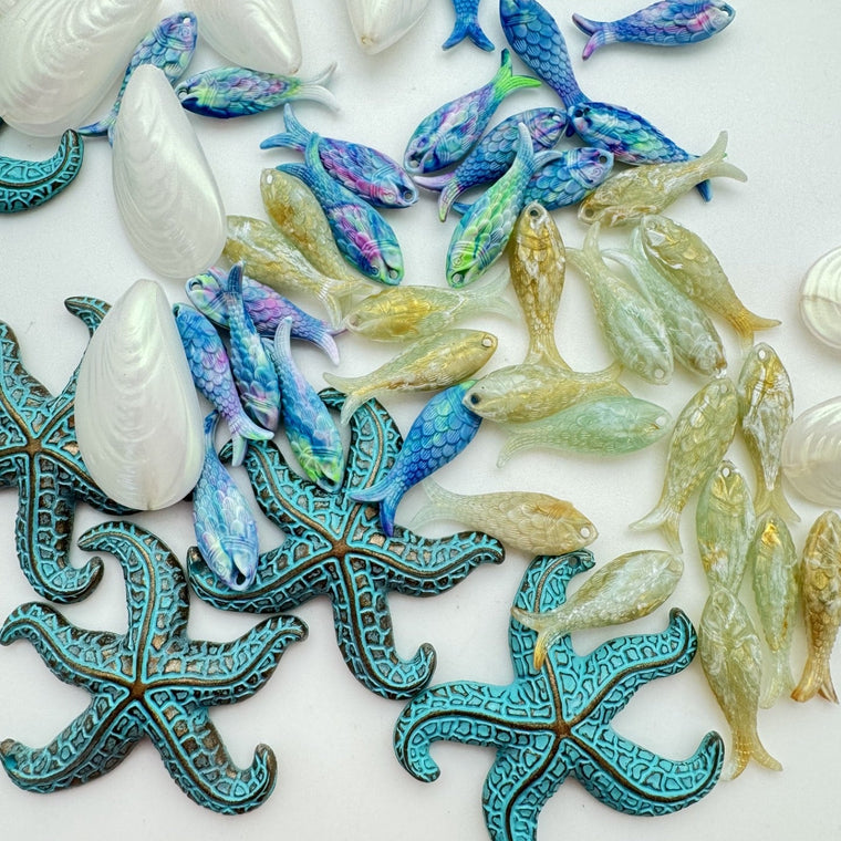Colorful resin sea-themed figurines including fish and starfish on a white background