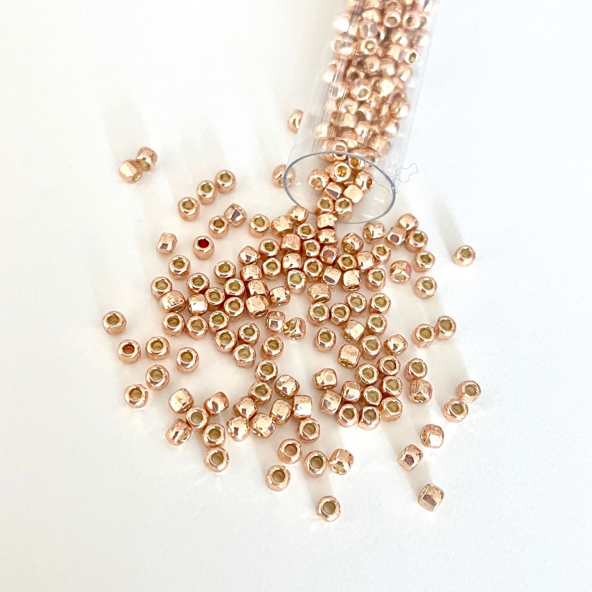 Like the warmth of the sun mixed with the creamy color of a rose this 3-cut size 8º rose gold seed bead shimmers in the light due to its 3 facets. A perfect bead to add to all of the metallic colors for a bit of flash. This bead has a permanent finish so the color will not rub off/Island Cove Beads & Gallery